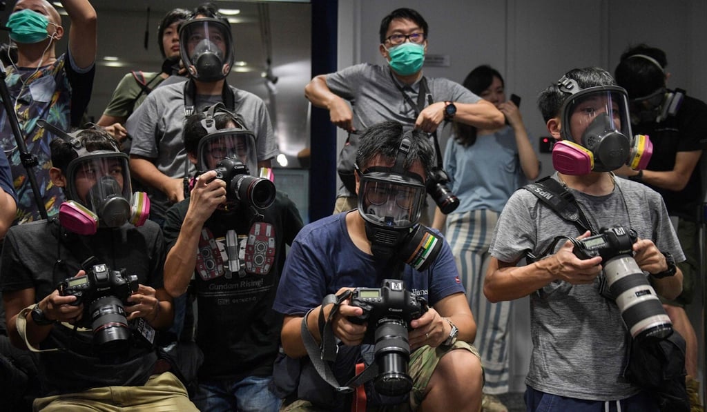 Photojournalists wearing gas masks in protest against police action at a press conference by the force last year. Photo: AFP