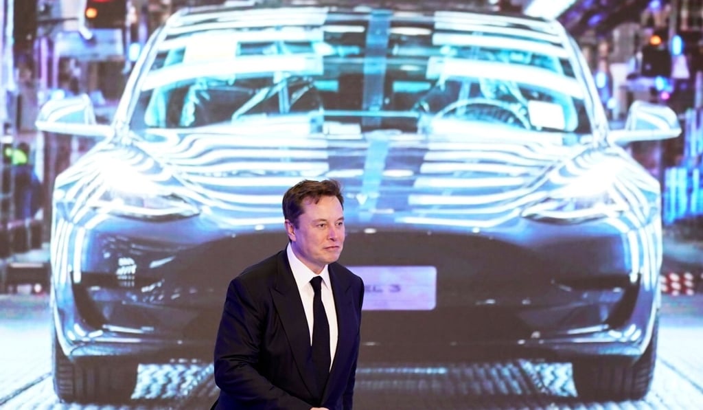 Tesla CEO Elon Musk walks next to a screen showing an image of a Model 3 car during an event in Shanghai in January. Photo: Reuters