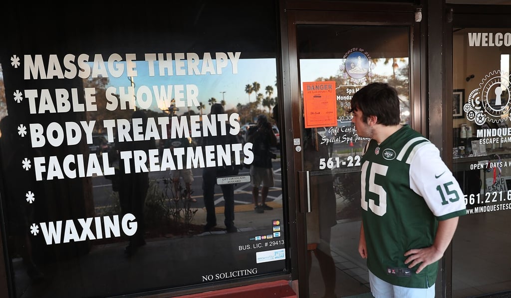 A football fan stops to look at the Orchids of Asia Day Spa in Florida where New England Patriots owner Robert Kraft was charged with allegedly soliciting for sex. Photo: AFP A football fan stops to look at the Orchids of Asia Day Spa in Florida where New England Patriots owner Robert Kraft was charged with allegedly soliciting for sex. Photo: AFP