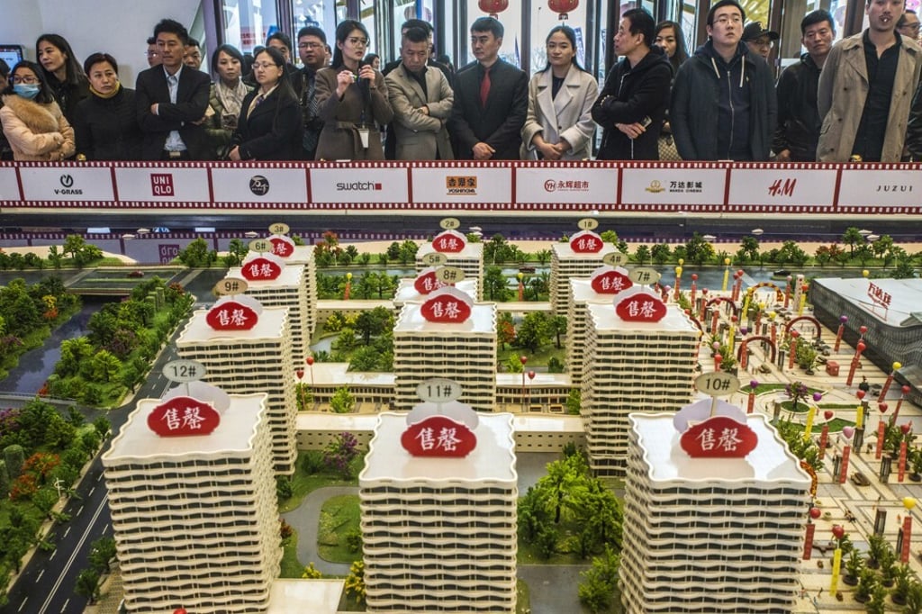Prospective customers look at a model of the Dalian Wanda Group’s Oriental Movie Metropolis at a showroom in Qingdao. Photo: Bloomberg Prospective customers look at a model of the Dalian Wanda Group’s Oriental Movie Metropolis at a showroom in Qingdao. Photo: Bloomberg