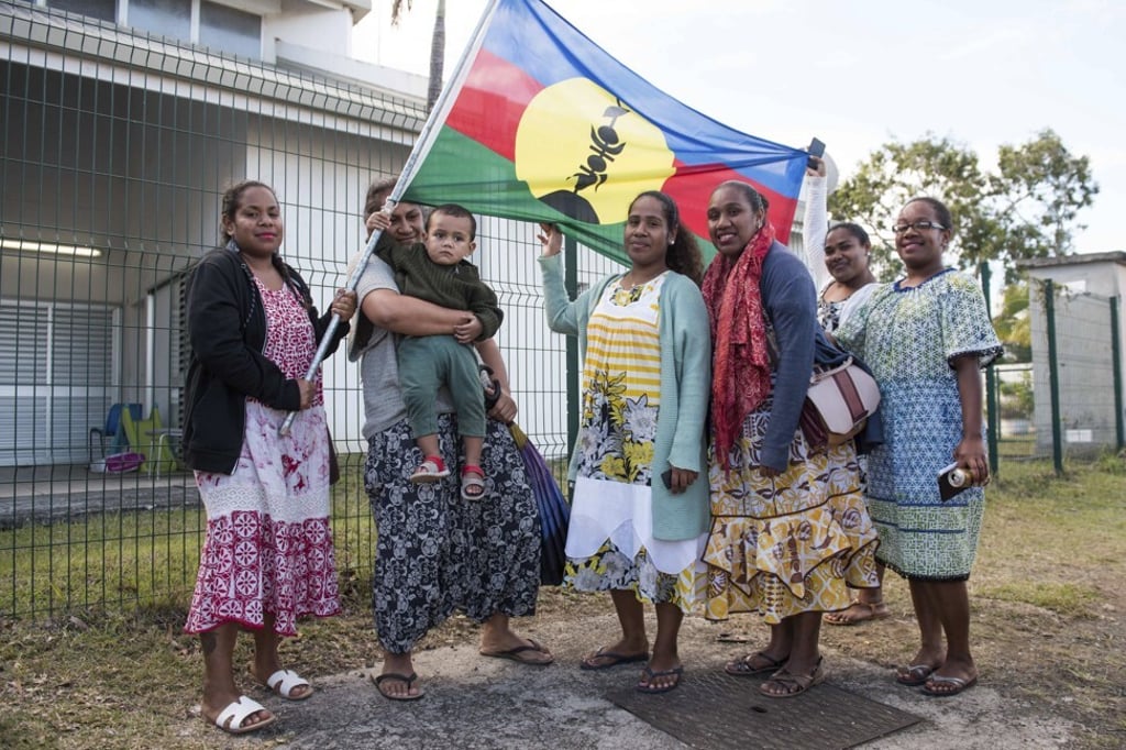 Independence supporters hold the Kanak flag in New Caledonia. Support for independence fell from a previous referendum, a partial vote count showed. Photo: AP