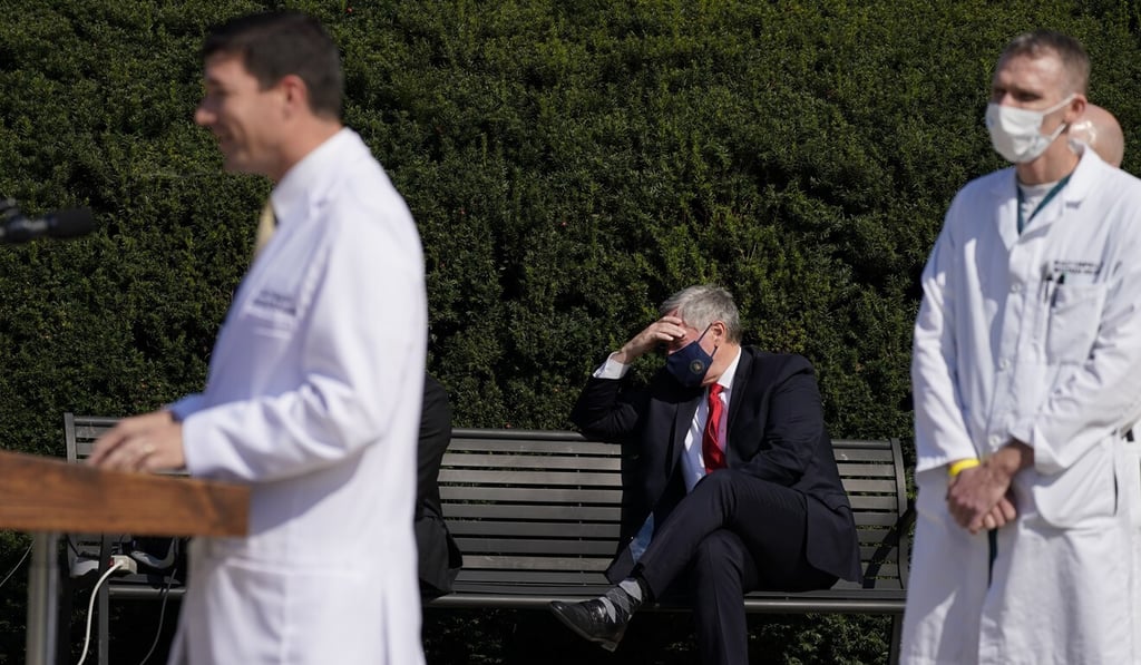 White House chief of staff Mark Meadows, centre, listens as Dr Sean Conley, doctor to US President Donald Trump, briefs reporters on Sunday. Photo: AP White House chief of staff Mark Meadows, centre, listens as Dr Sean Conley, doctor to US President Donald Trump, briefs reporters on Sunday. Photo: AP