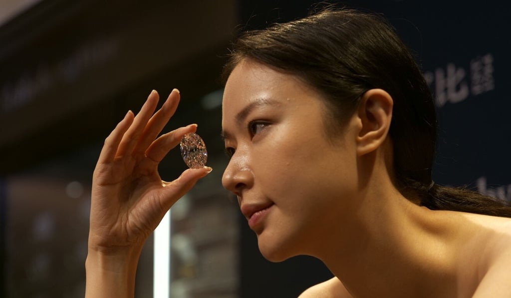 A model holds the 102.39-carat flawless oval diamond bought by an unnamed telephone bidder for HK$122 million at auction in Hong Kong on Monday. Photo: AFP A model holds the 102.39-carat flawless oval diamond bought by an unnamed telephone bidder for HK$122 million at auction in Hong Kong on Monday. Photo: AFP