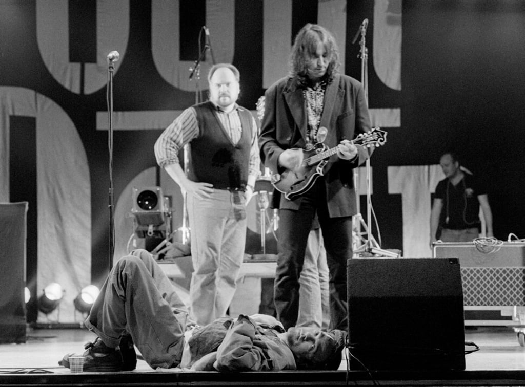 Michael Stipe (lying down) and guitarist Peter Buck from American band R.E.M. perform in the Netherlands in 1991. Photo: Getty Images