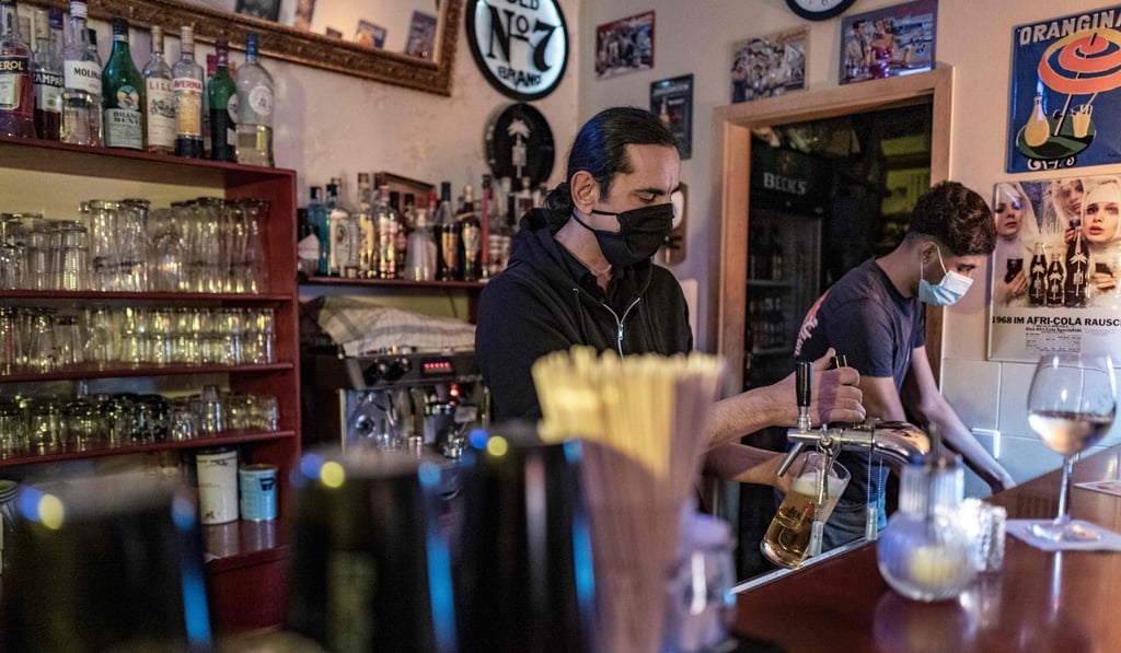 A bar worker pours a beer at a bar in Berlin's Prenzlauer Berg district on Saturday. Photo: AFP