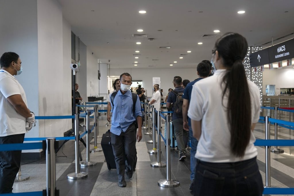 Departing cruise line passengers wait to pass through the thermal screening system before immigration control at the Singapore Cruise Centre in Singapore in March 2020. Photo: Bloomberg