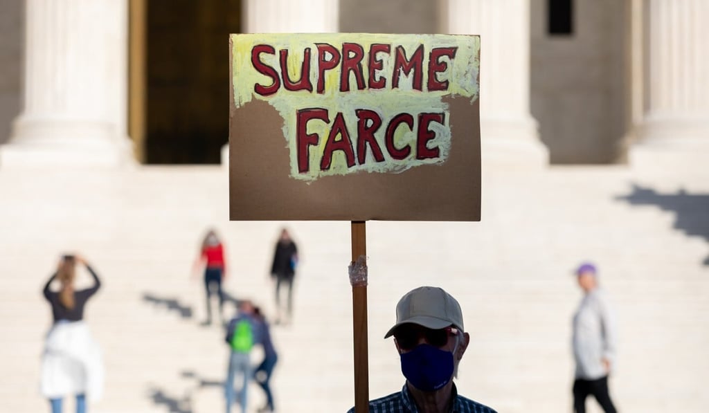 A demonstrator holds a sign that reads “Supreme Farce” during a protest outside the US Supreme Court on Tuesday. Photo: Bloomberg