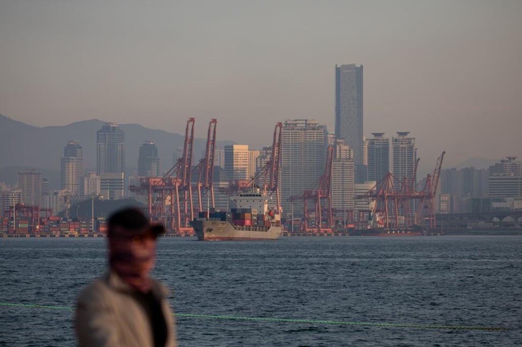 A man passes container ships docked at the Port of Busan in Busan, South Korea. Asian export powerhouses such as China and South Korea are highly dependent on the health of the global economy. Photo: Bloomberg