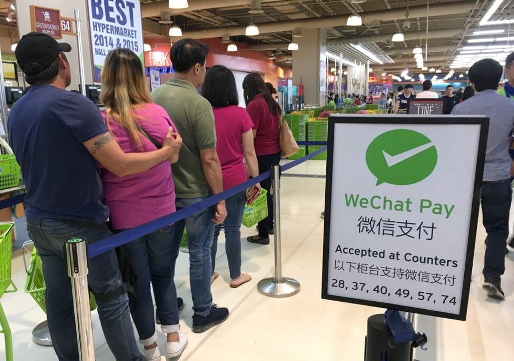Shoppers﻿ queue to make payment on May 30, 2019, at a supermarket in Manila that accepts WeChat Pay. In the Philippines, only 1 per cent of retail payments were made electronically five years ago, despite 41 per cent of the population having internet access. Photo: Phila Siu
