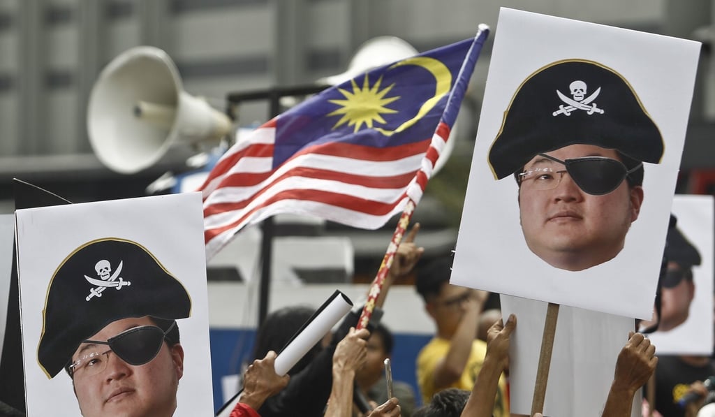 Protesters hold portraits of Jho Low depicted with a pirate hate and eyepatch during a protest in Kuala Lumpur, Malaysia in April 2018. Photo: AP