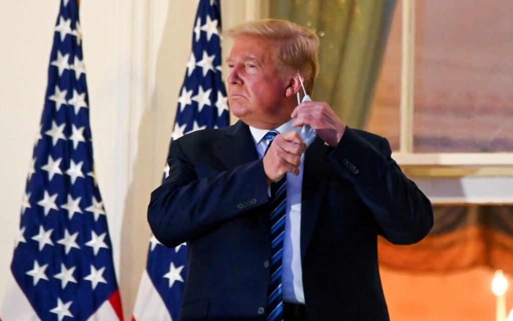 President Donald Trump pulls off his protective face mask after returning from being hospitalised on October 5. Photo: Reuters