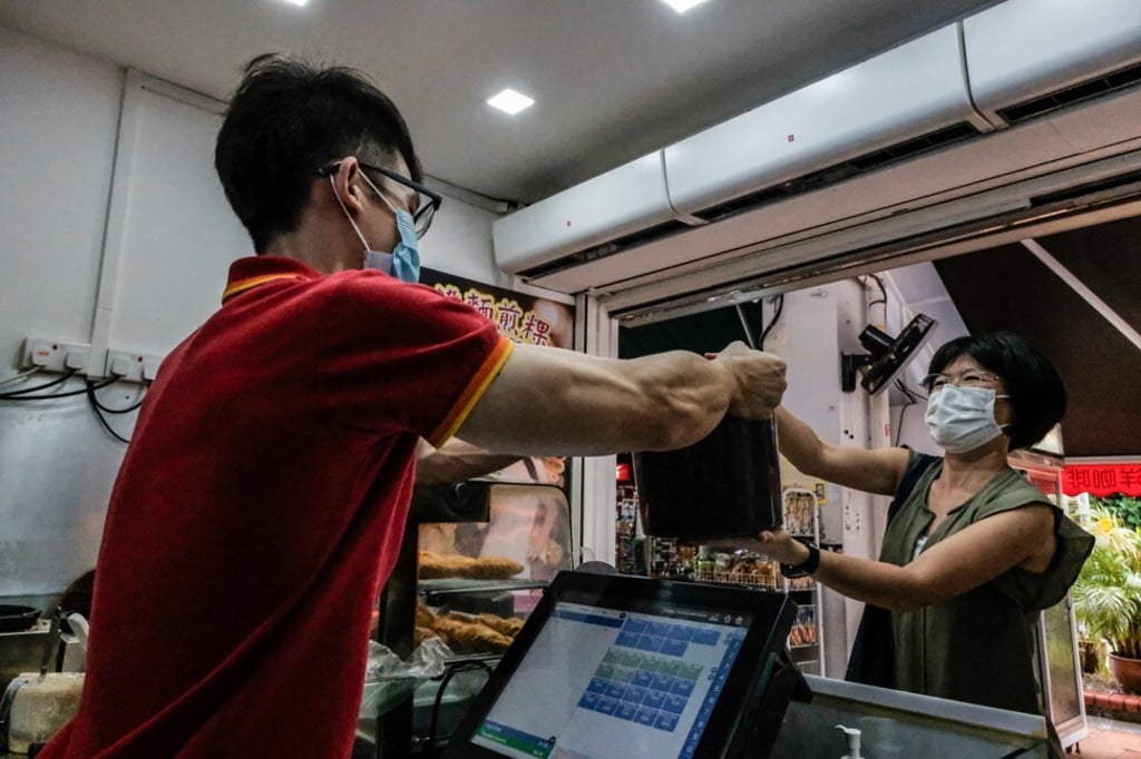 Pui Cuifen picks up tubs of used coffee grinds at the Yuhua Village Market and Food Centre for composting. Photo: Toh Ee Ming