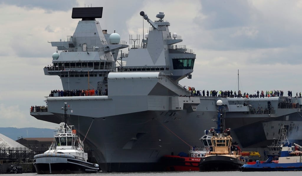 The British aircraft carrier HMS Queen Elizabeth is pulled from its berth by tugboats before its maiden voyage, in Rosyth, Scotland in June 2017. Photo: Reuters
