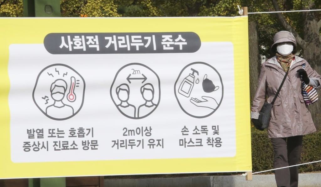 A woman wearing a face mask walks past a sign detailing antivirus precautions at a park in Goyang, South Korea, earlier this month. Photo: AP A woman wearing a face mask walks past a sign detailing antivirus precautions at a park in Goyang, South Korea, earlier this month. Photo: AP