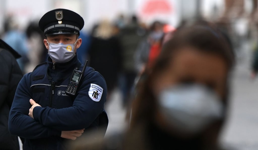 A German police officer checks to make sure pedestrians in Munich are wearing face masks on Thursday. Photo: AFP