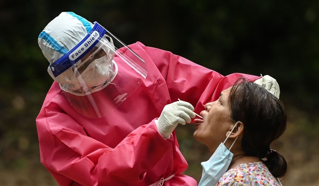 A medical worker take a swab sample of a woman to test for Covid at a quarantine facility in Yangon. Photo: AFP