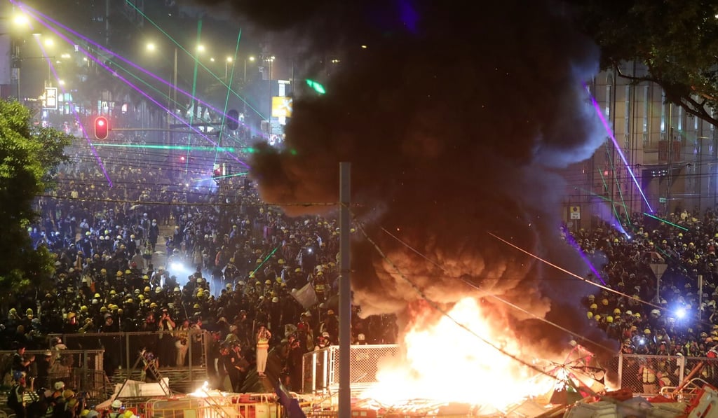 Anti-government protesters set metal barricades on fire on Hennessy Road in Wan Chai. Photo: Sam Tsang Anti-government protesters set metal barricades on fire on Hennessy Road in Wan Chai. Photo: Sam Tsang