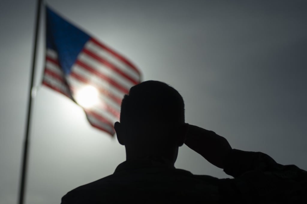 A US Air Force staff sergeant salutes the American flag during a ceremony at a military base in Kenya in August 2019. The US now deploys troops in more than 170 countries and has some 800 overseas military bases. Photo: AP