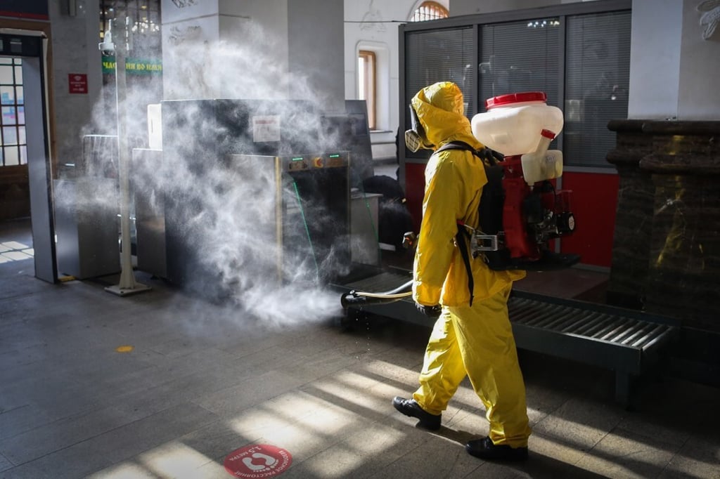 A worker sprays disinfectant at a railway station in Moscow. Photo: Bloomberg