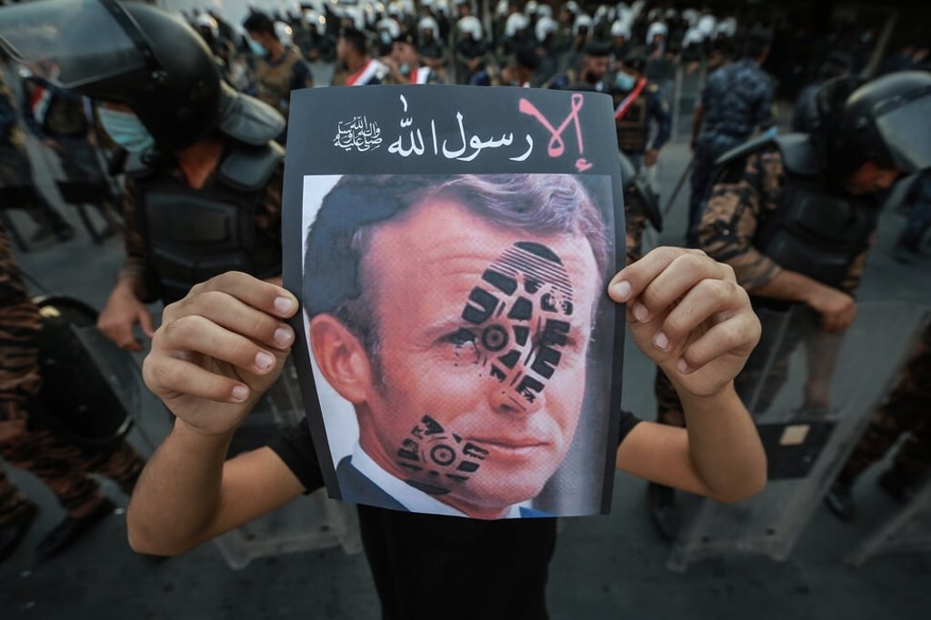 A protester holds a picture of French President Emmanuel Macron in Baghdad. Photo: dpa A protester holds a picture of French President Emmanuel Macron in Baghdad. Photo: dpa