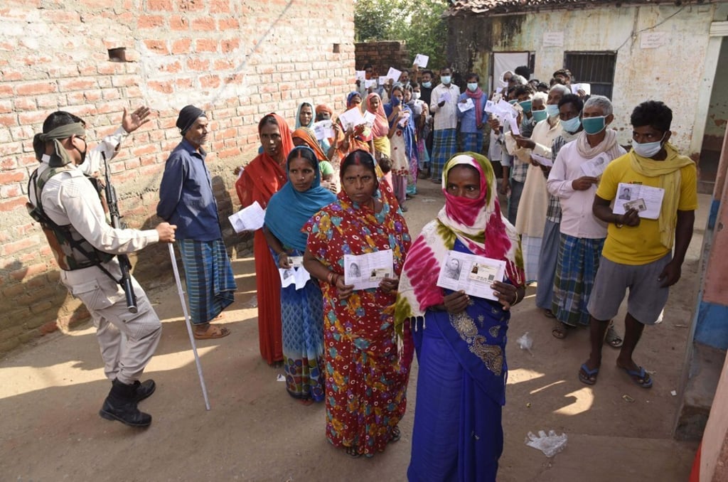 Voters display their identity cards outside a polling station at Paliganj. Photo: AP