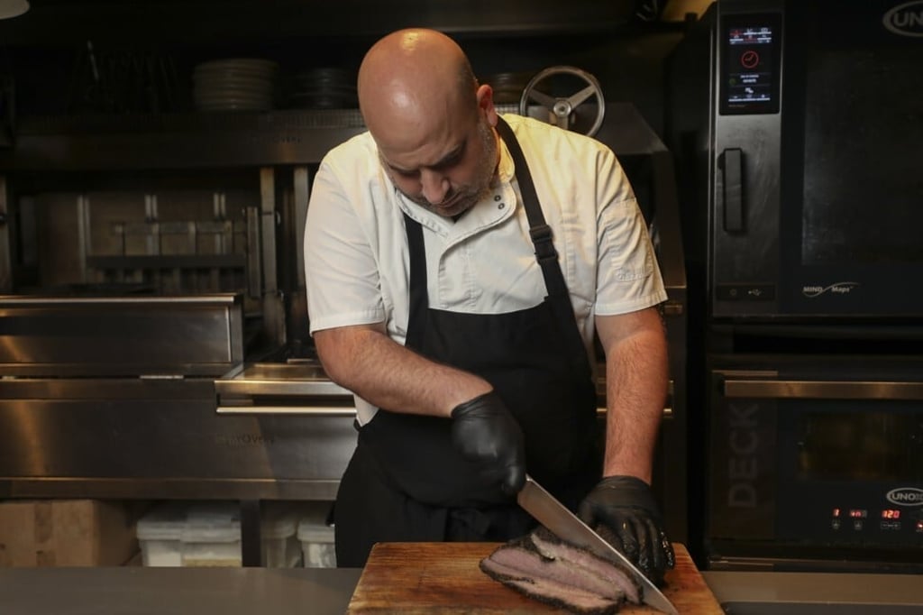 Chef Asher Goldstein slices barbecued meat at Mr. Brown in Wan Chai, which is a self-styled neighbourhood smoke and grill house. Photo: Xiaomei Chen