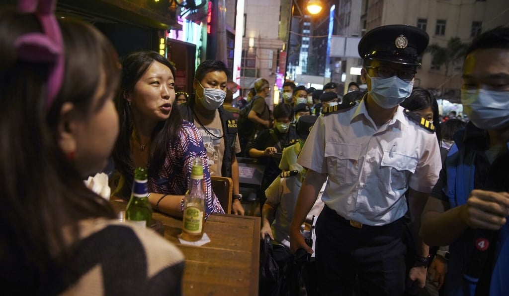 Police officers patrol as people drink at bar in Lan Kwai Fong during Halloween night. Photo: SCMP / Winson Wong