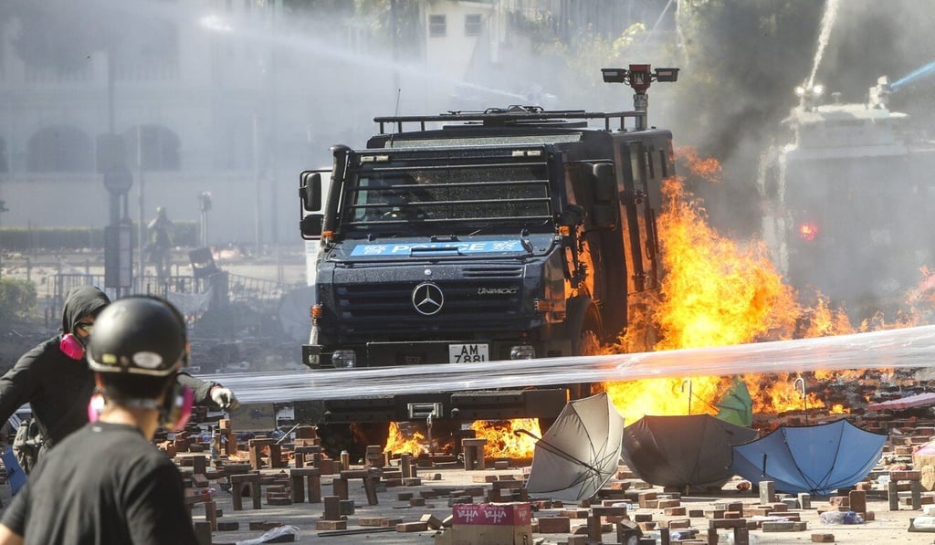 An armoured police vehicle is surrounded by flames during a clash at the Hong Kong Polytechnic University in November 2019. Photo: Winson Wong