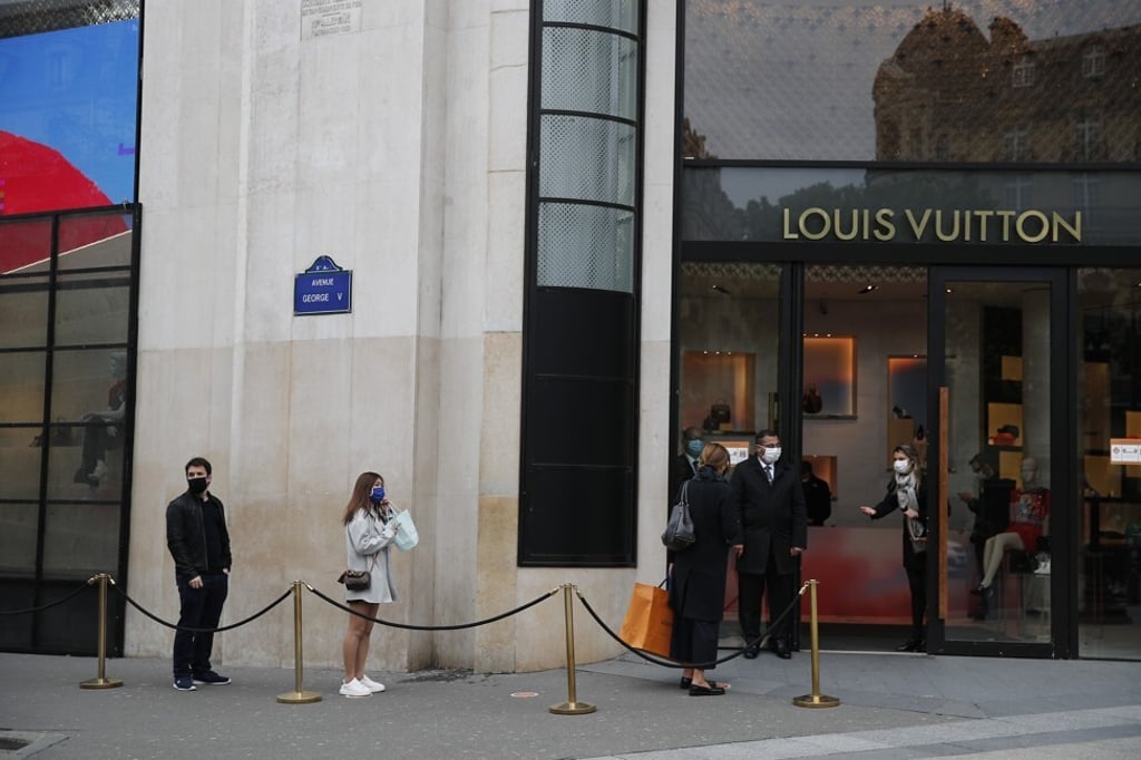 Clients queue up in front of Louis Vuitton in May 2020 in Paris as France cautiously lifted its lockdown. Photo: AP Photo