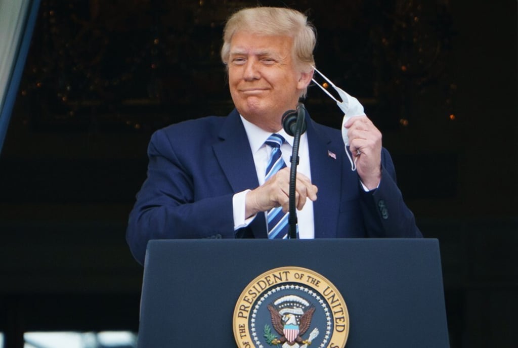 Donald Trump takes his mask off before speaking at a White House rally after leaving hospital following treatment for Covid-19. Photo: AFP Donald Trump takes his mask off before speaking at a White House rally after leaving hospital following treatment for Covid-19. Photo: AFP