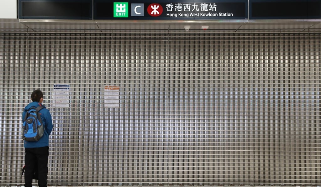 A commuter reads the notice on the gate at the closed West Kowloon station. Photo: Winson Wong
