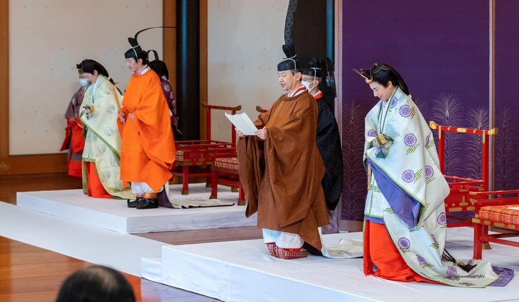 Japan's Crown Prince Akishino, in orange robe, flanked by Crown Princess Kiko, left, with Emperor Naruhito, second from right, Empress Masako, right, and other royal family members at the Imperial Palace in Tokyo on Sunday. Photo: Reuters