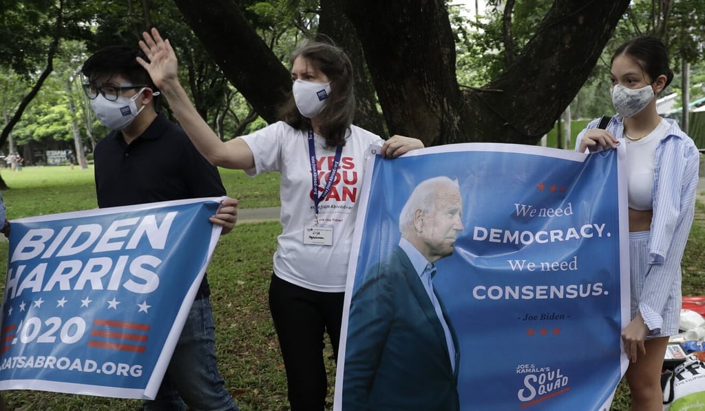 Members of the Democrats Abroad Philippines hold slogans with images of President-elect Joe Biden in Makati, the Philippines. Photo: AP