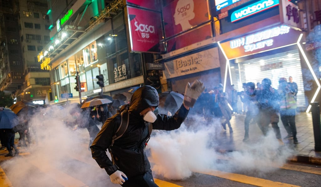 Pro-democracy protesters are hit by tear gas fired by police during a rally in Tsim Sha Tsui in December 2019. Photo: EPA-EFE