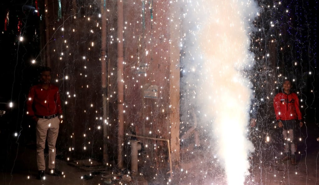 People watch as firecrackers burn during Diwali, the Hindu festival of lights, in New Delhi, India on Saturday. Photo: Reuters