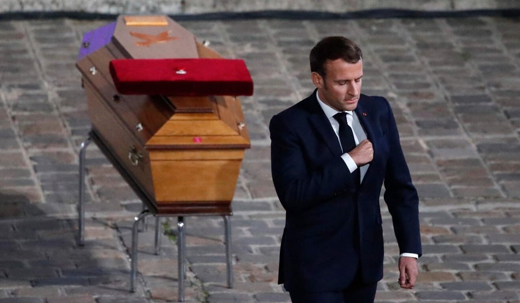French President Emmanuel Macron pays his respects by the coffin of slain teacher Samuel Paty. Photo: AFP