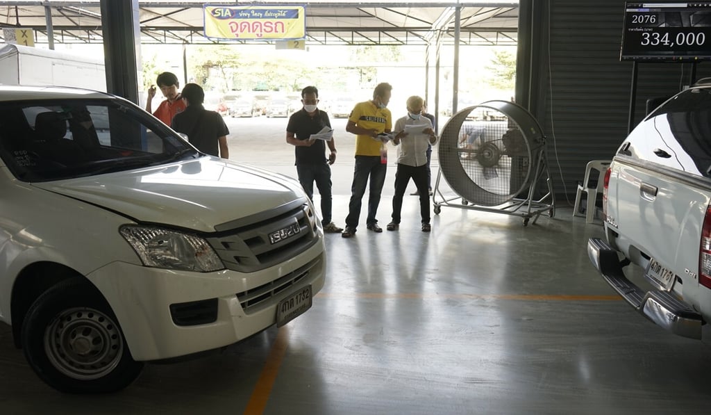 Potential buyers assess lists of second-hand cars at the SIA warehouse. Photo: Vijitra Duangdee Potential buyers assess lists of second-hand cars at the SIA warehouse. Photo: Vijitra Duangdee