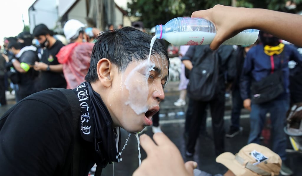 A protester has his eyes doused with milk during an anti-government demonstration in Bangkok. Photo: Reuters