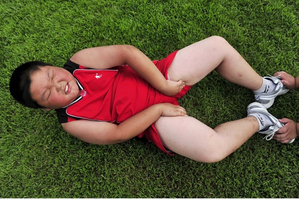 An obese Chinese boy does sit-ups as he takes part in a weight-loss camp in Shenyang, Liaoning province, China. Photo: AFP