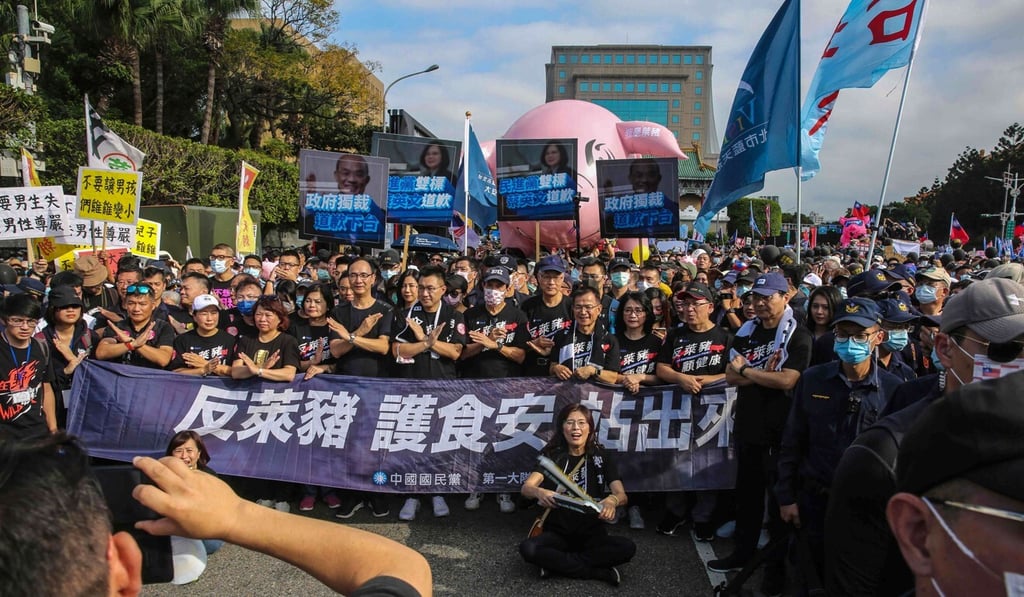 Kuomintang chairman Johnny Chiang (front row centre) and former Taiwanese president Ma Ying-jeou (front centre right wearing face mask) lead party members and supporters during the annual pro-labour march in Taipei on Sunday. Photo: AFP