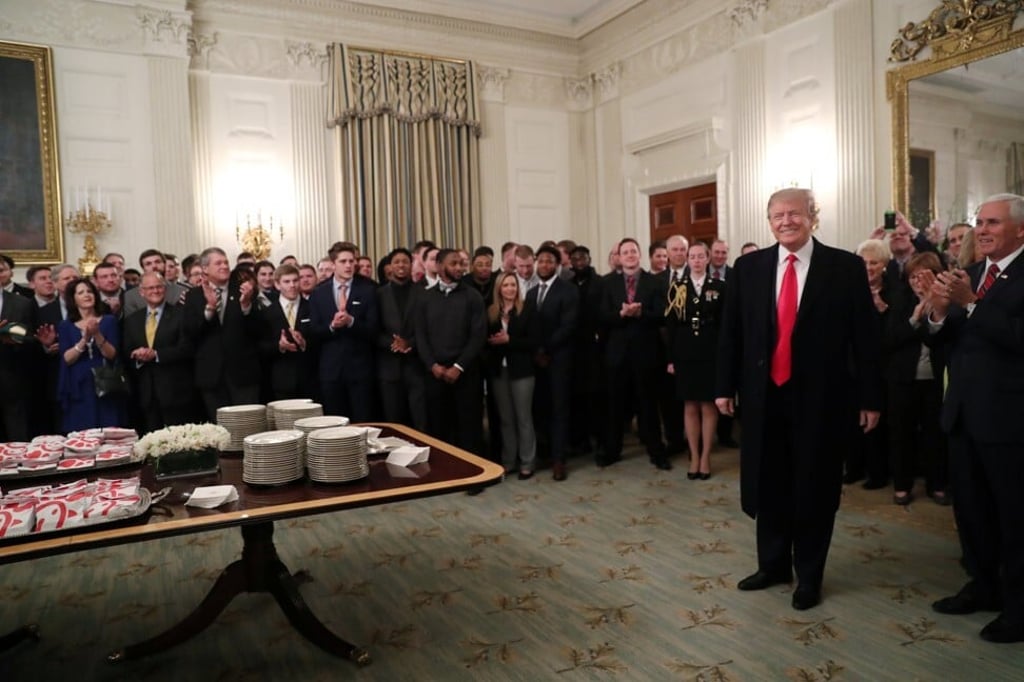 Members of the North Dakota State University football team behind a table of fast food sandwiches from McDonald's and Chick-fil-A in the East Room of the White House in 2019. Photo: Reuters