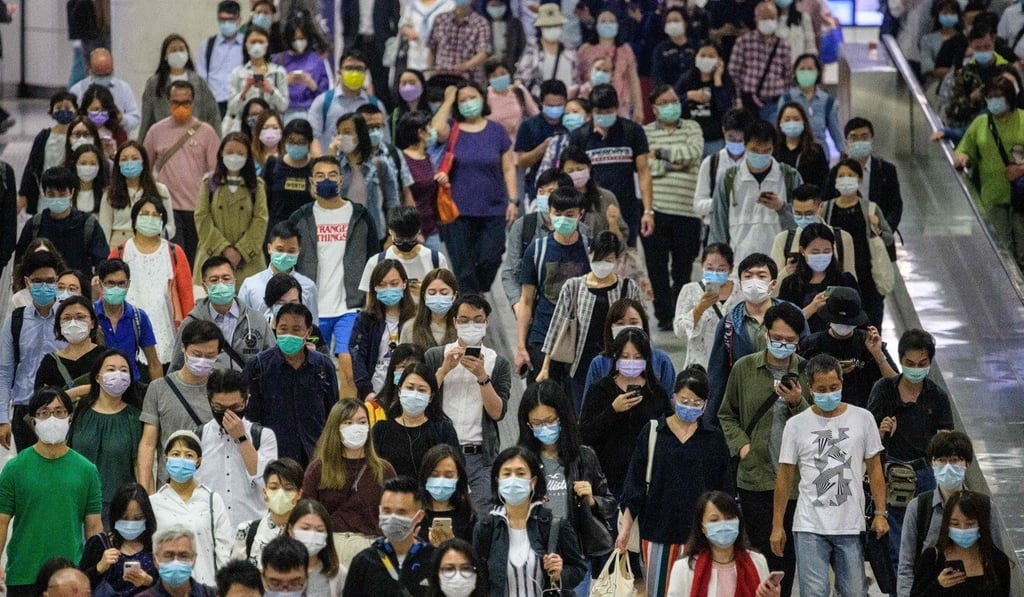 Commuters in Hong Kong wearing masks walk through an MTR station. The city’s economy has been severely battered by the Covid-19 pandemic. Photo: AFP Commuters in Hong Kong wearing masks walk through an MTR station. The city’s economy has been severely battered by the Covid-19 pandemic. Photo: AFP
