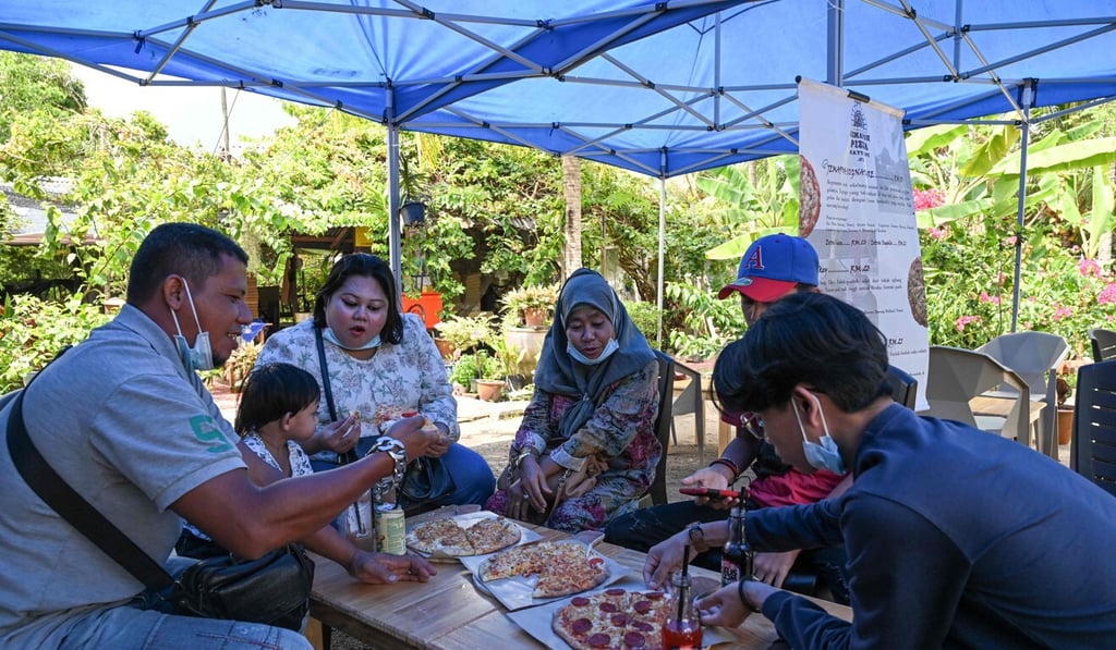Customers eating pizzas at the Jemapoh restaurant in Malaysia. Photo: AFP