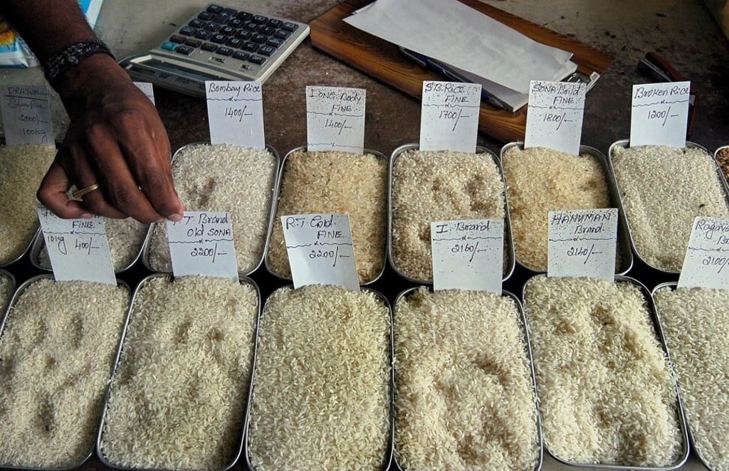 A wholesale rice seller puts price tags for different varieties of rice at his shop in Bangalore, India. Photo: EPA