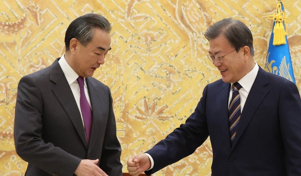 Chinese Foreign Minister Wang Yi,left, briefly hesitates as South Korean President Moon Jae-in made an unscheduled offer of his hand during the latter's courtesy call at the presidential office in Seoul, South Korea, last week. Photo: EPA-EFE