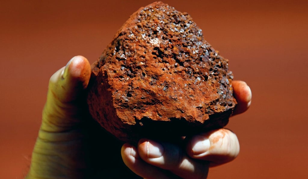 A miner holds a lump of iron ore at a mine located in the Pilbara region of Western Australia. Photo: Reuters A miner holds a lump of iron ore at a mine located in the Pilbara region of Western Australia. Photo: Reuters