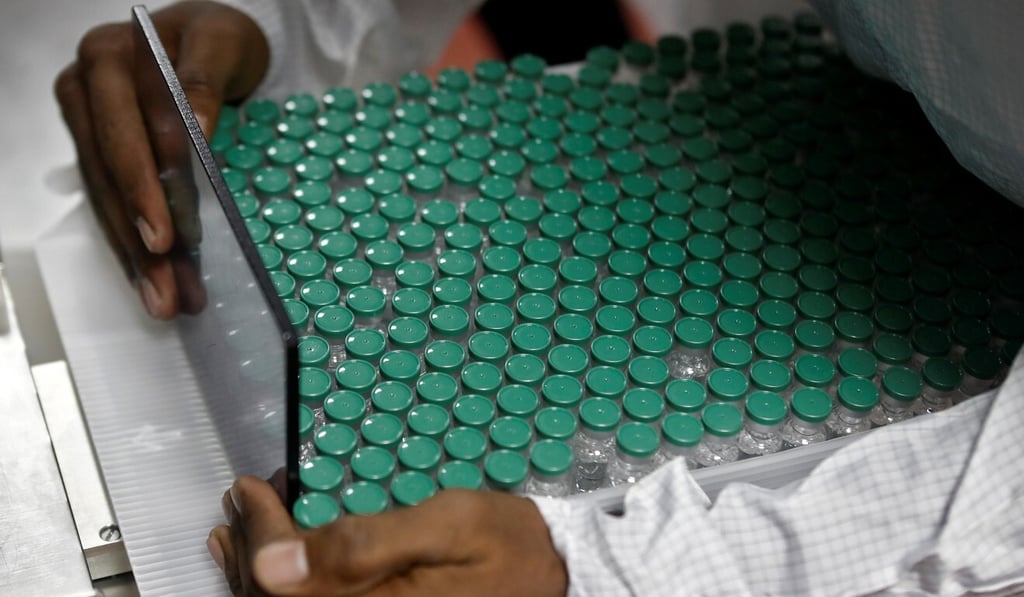 An employee at the Serum Institute of India removes vials of AstraZeneca's coronavirus vaccine from a visual inspection machine. Photo: Reuters