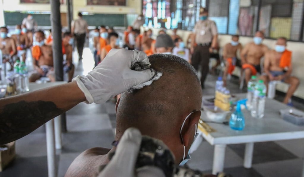 An artist removes a tattoo of an inmate at the New Bilibid Prison in Manila. Photo: AFP