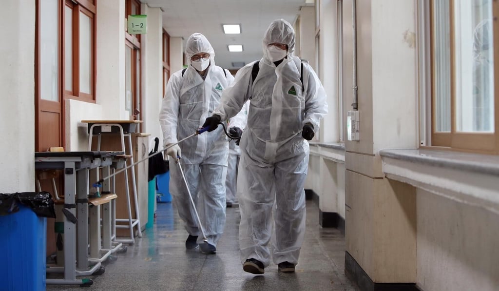 Health workers disinfect a school in Daegu on November 26. Photo: EPA