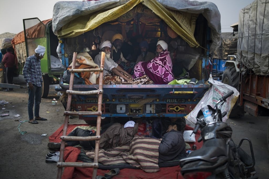 Indian farmers huddle together in the back of their tractor trailer in Delhi on December 1, 2020. Photo: AP
